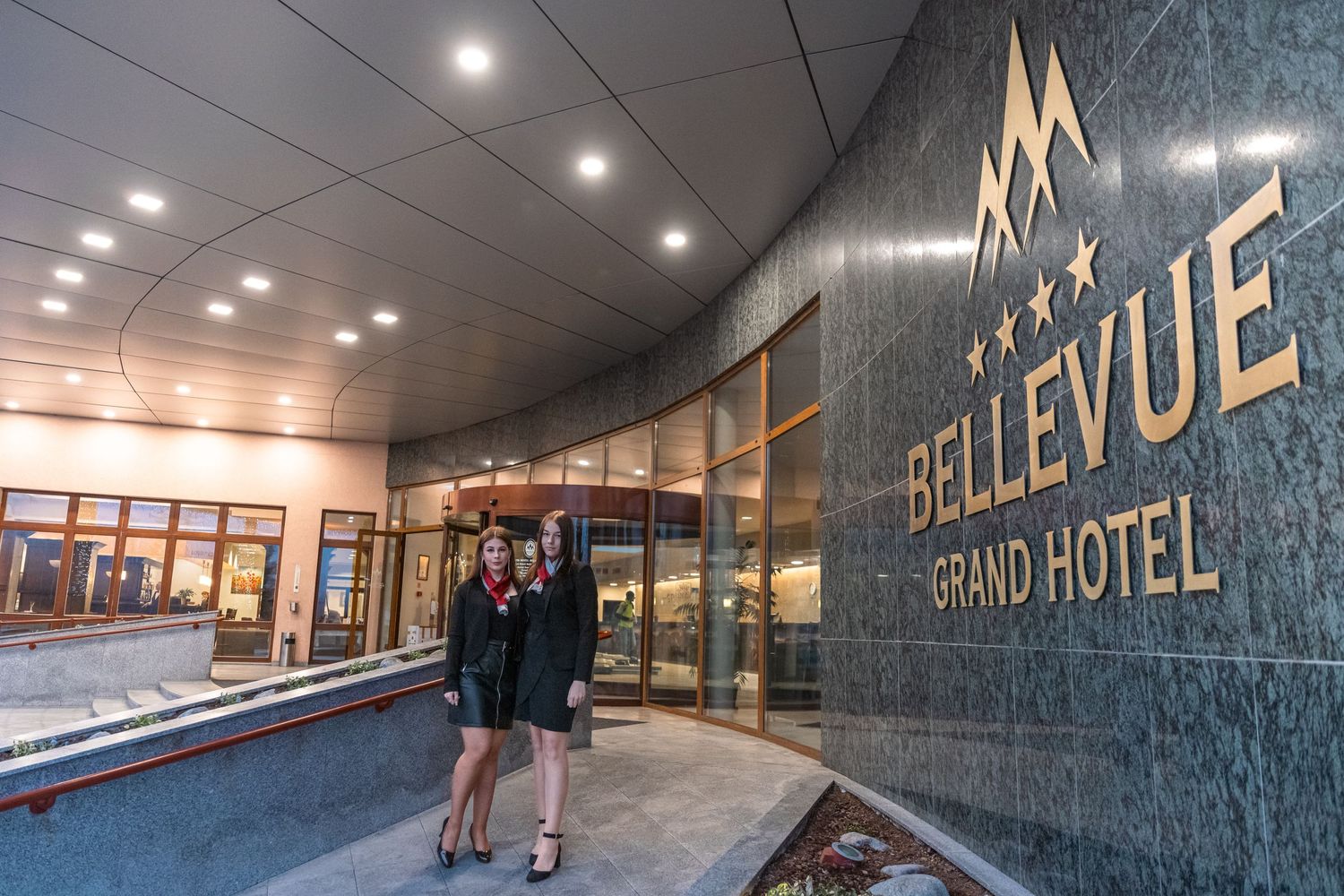 Modern hotel interior hallway with illuminated Bellevue Grand Hotel signage.