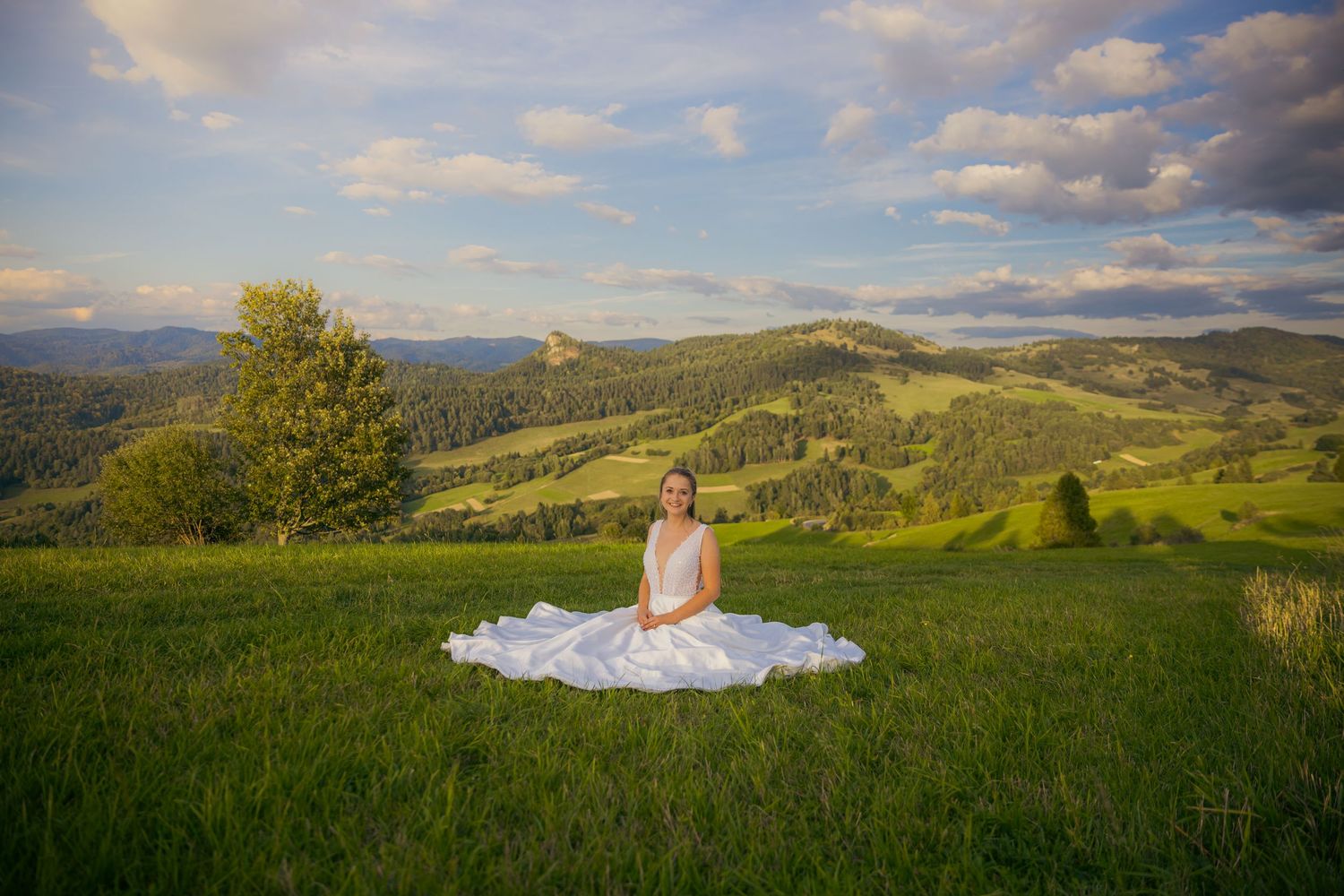 Scenic mountain landscape with green meadows and dramatic clouds at golden hour.
