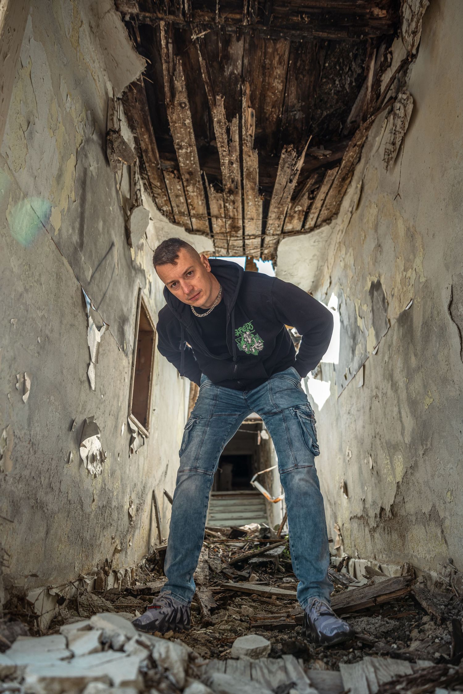 Explorer navigates through a dark, abandoned building interior.