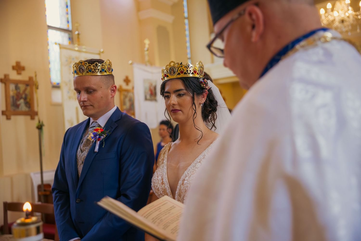 Traditional church wedding ceremony with elegant chandeliers and ornate interior decorations.