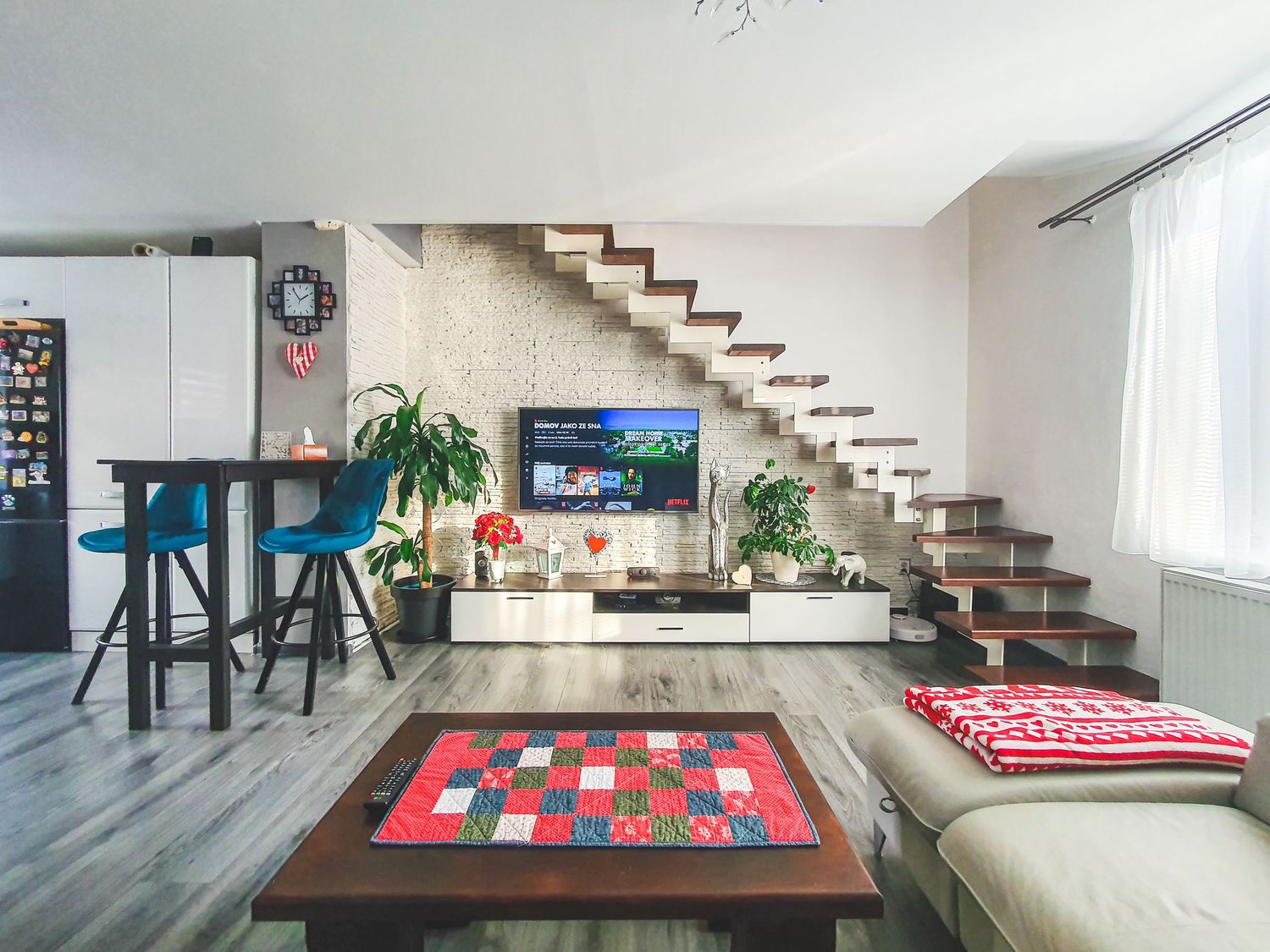 Modern minimalist interior with floating stairs and colorful area rugs.