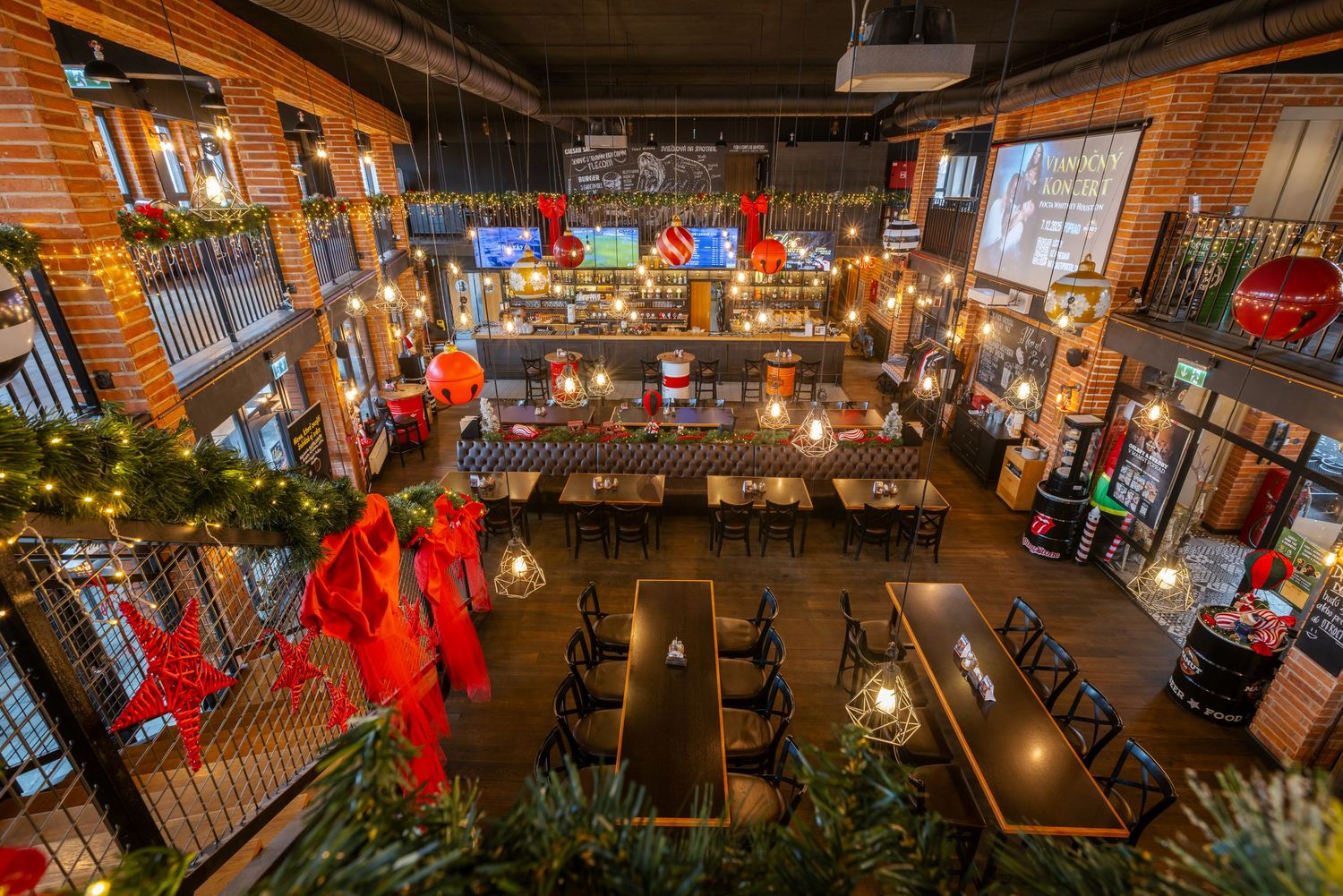 Restaurant interior with brick walls, hanging lights, and Christmas decorations creating a warm atmosphere.