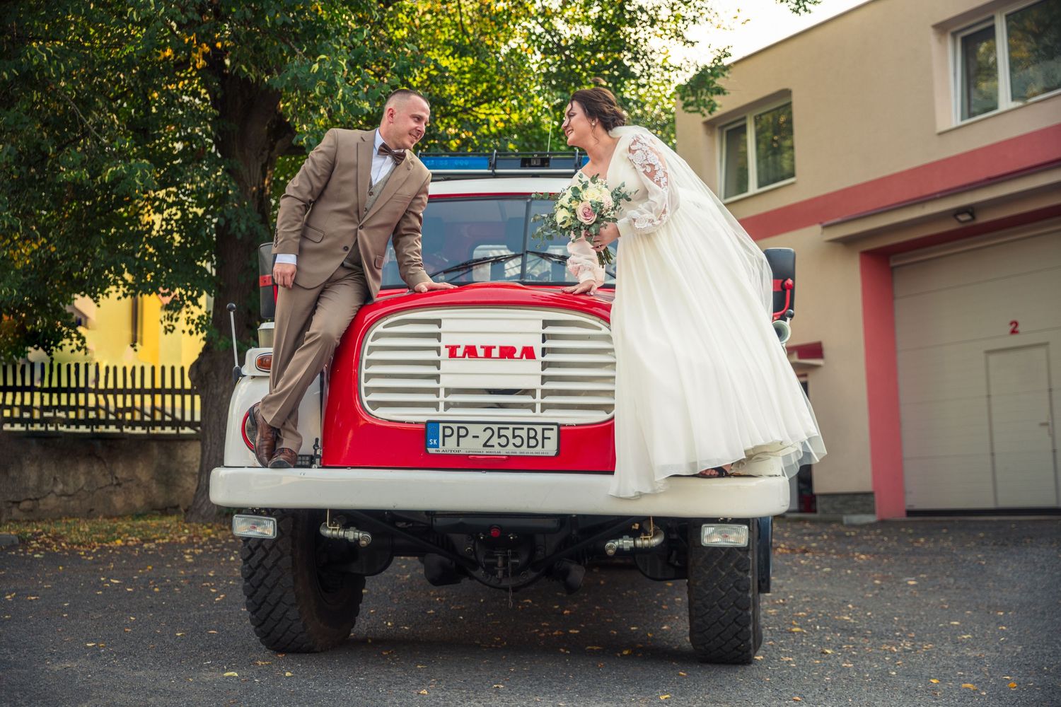 A vintage red truck being used for wedding transportation in an outdoor setting.