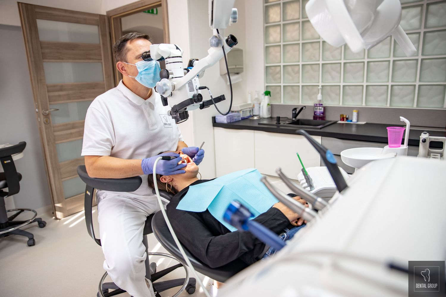 Modern dental office interior with professional equipment and examination chair in clean white setting.