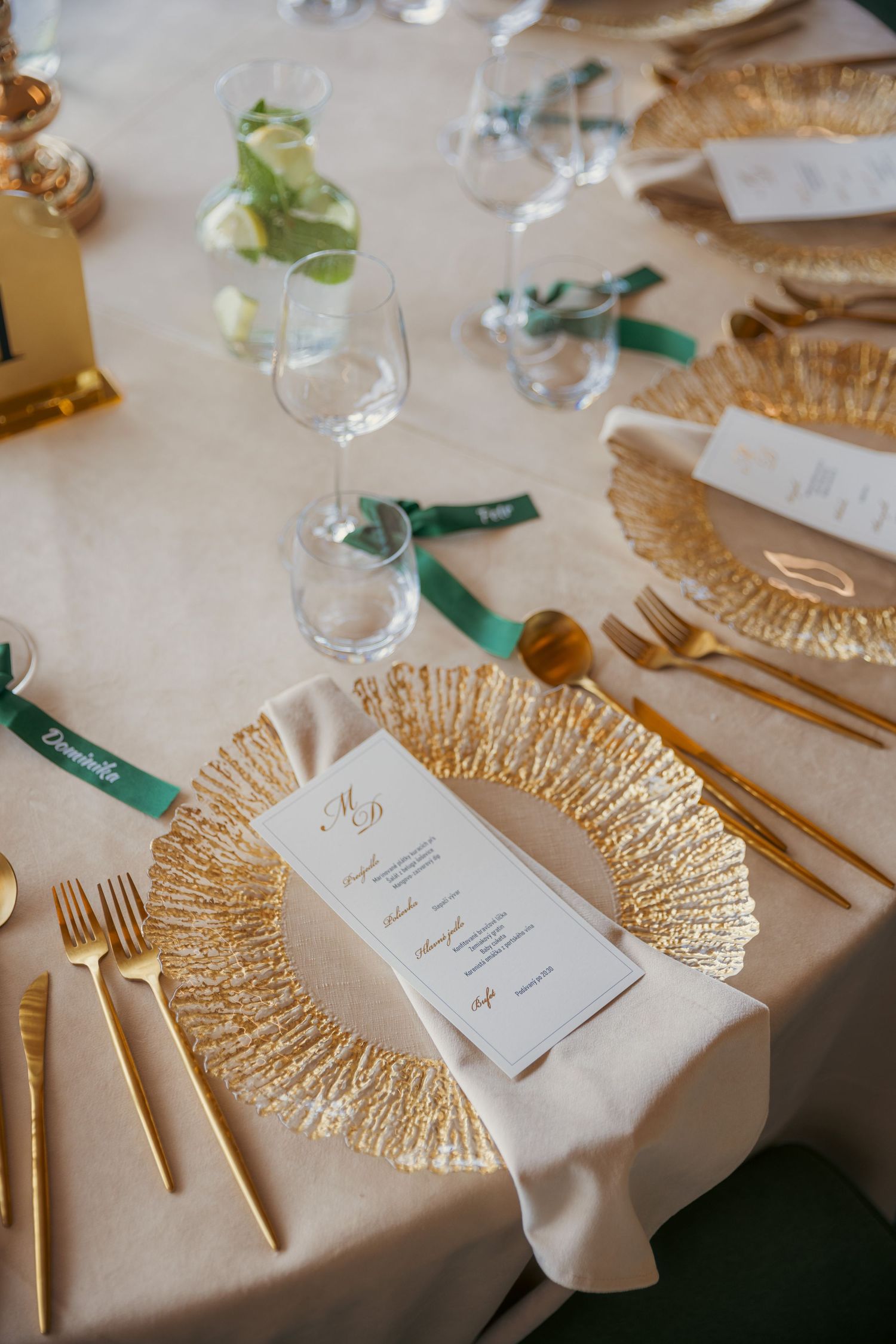 Elegant place settings with gold fan decorations and menu cards at wedding reception.