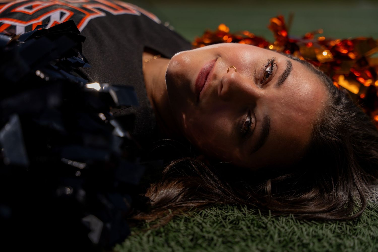 Athlete lying on grass with dramatic lighting.