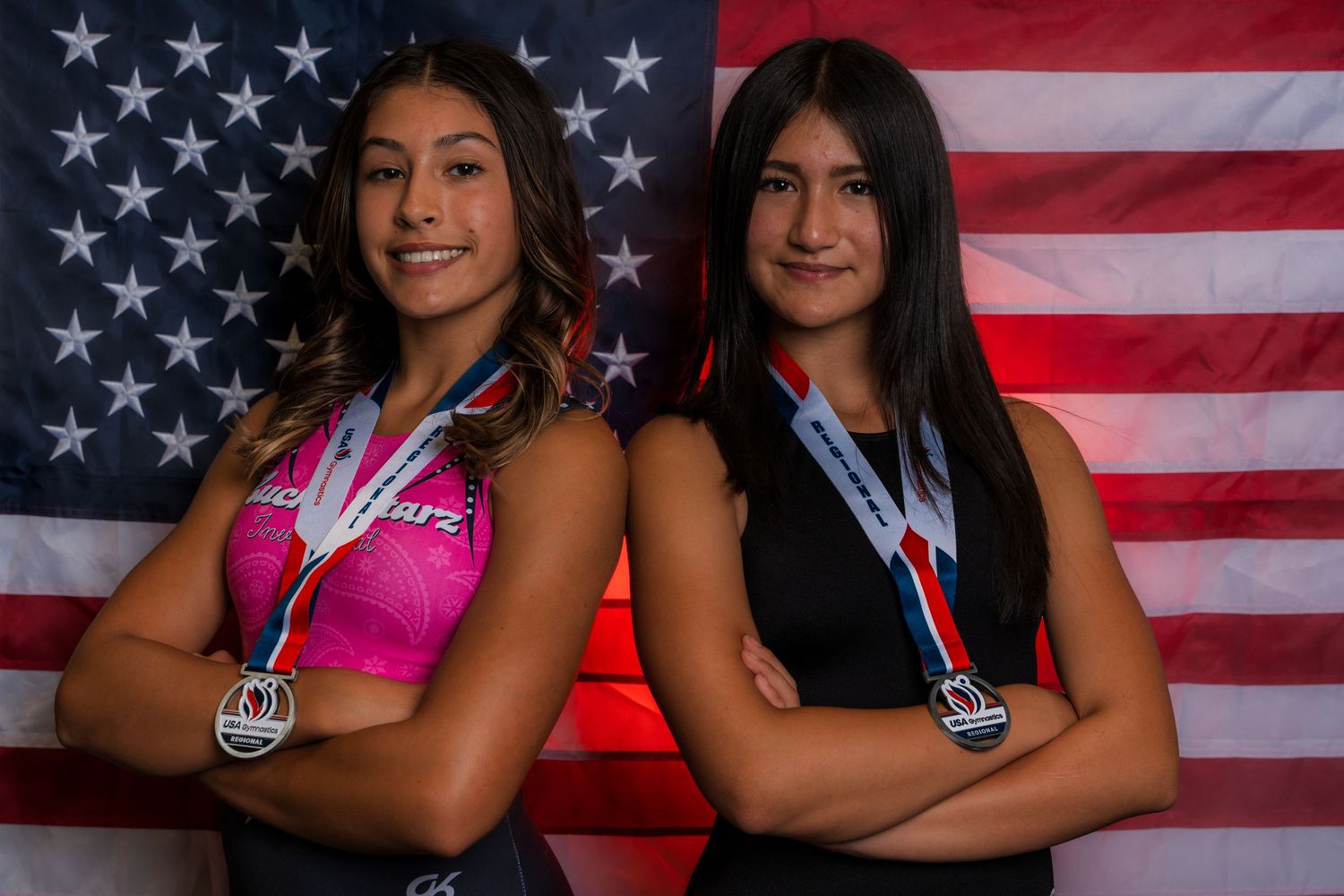 Group photo of athletes posing in front of American flag with medals.