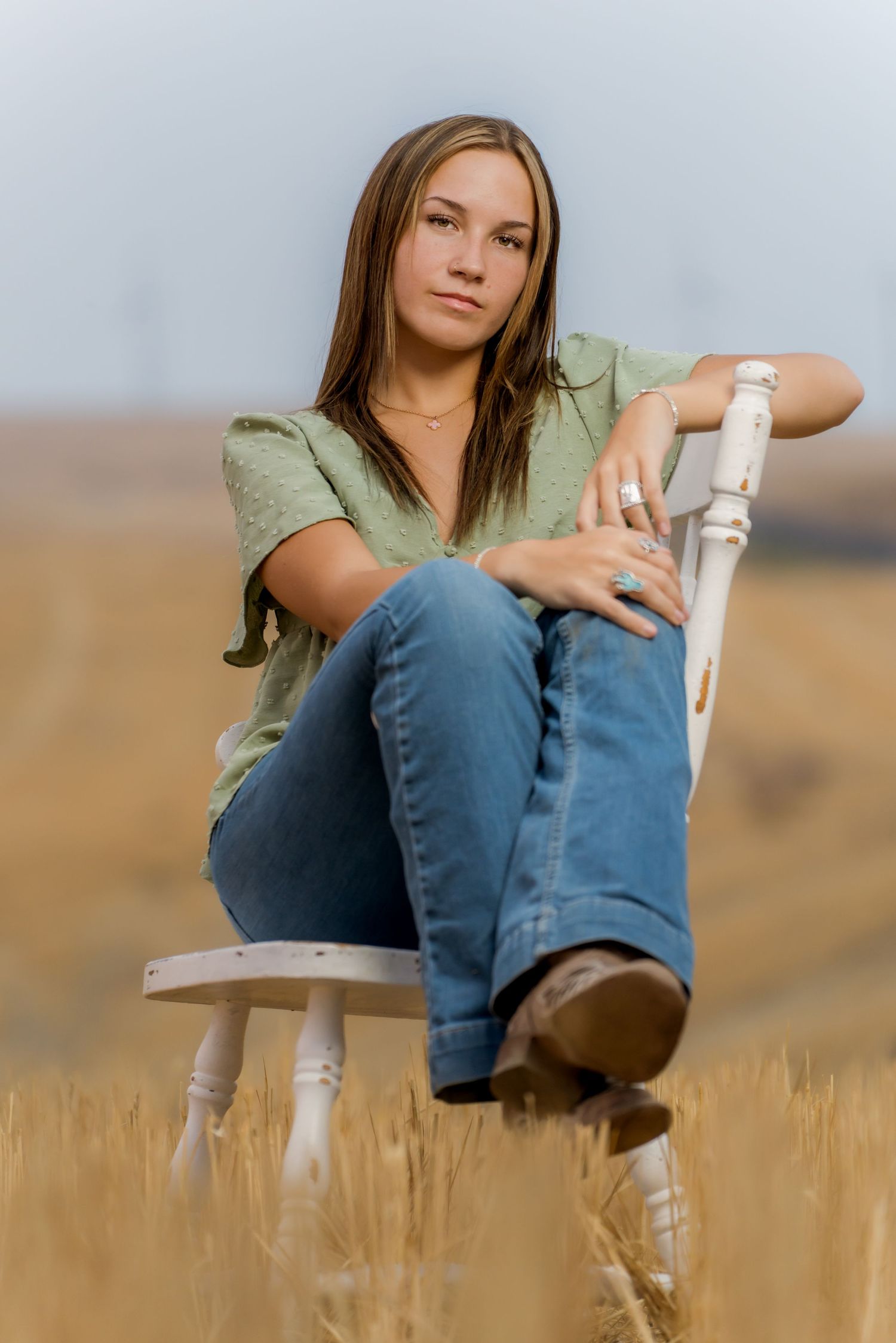 Senior portrait in Eastern Washington countryside with golden hour glow and natural posing.
