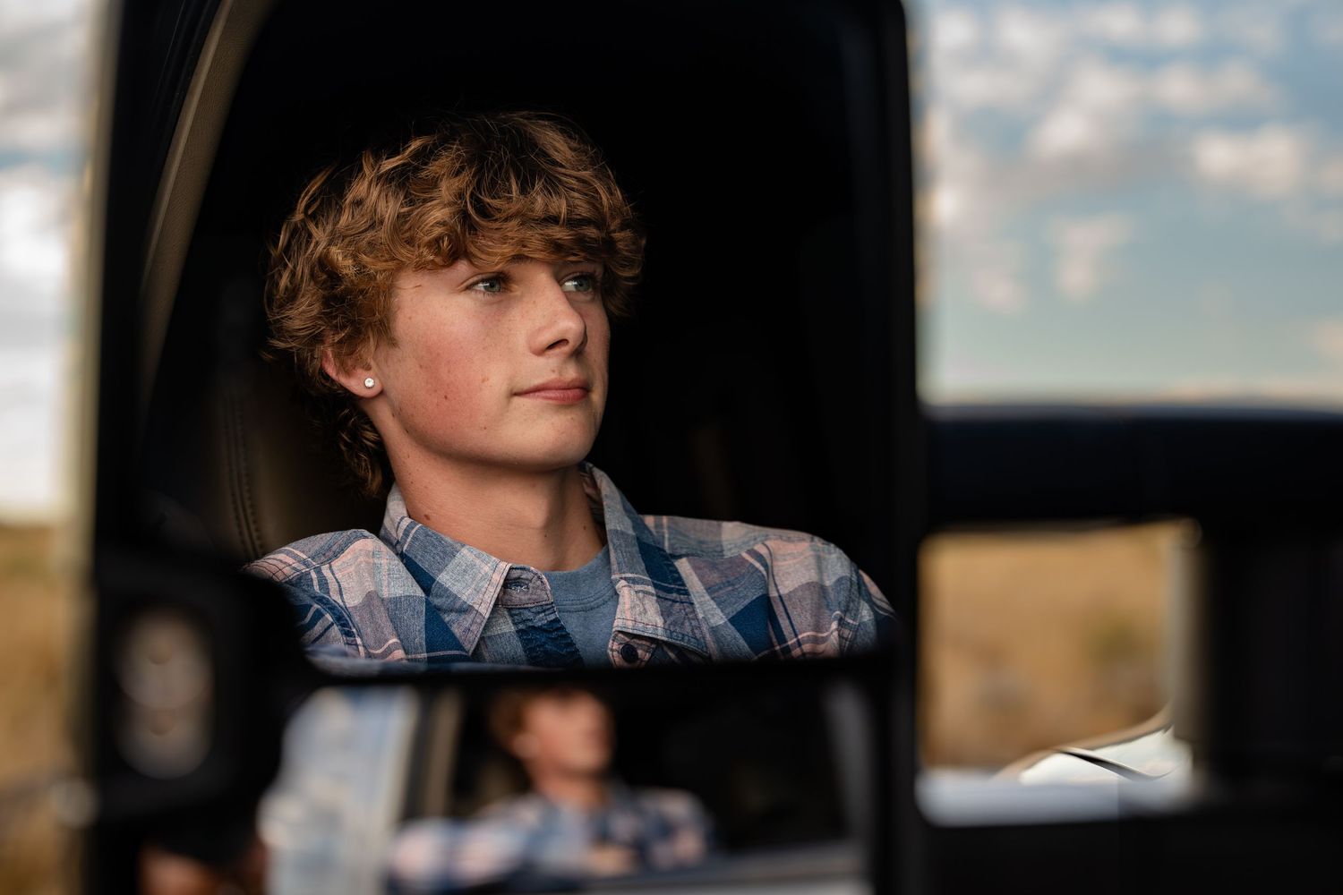 Senior portrait shot through truck window with natural lighting.