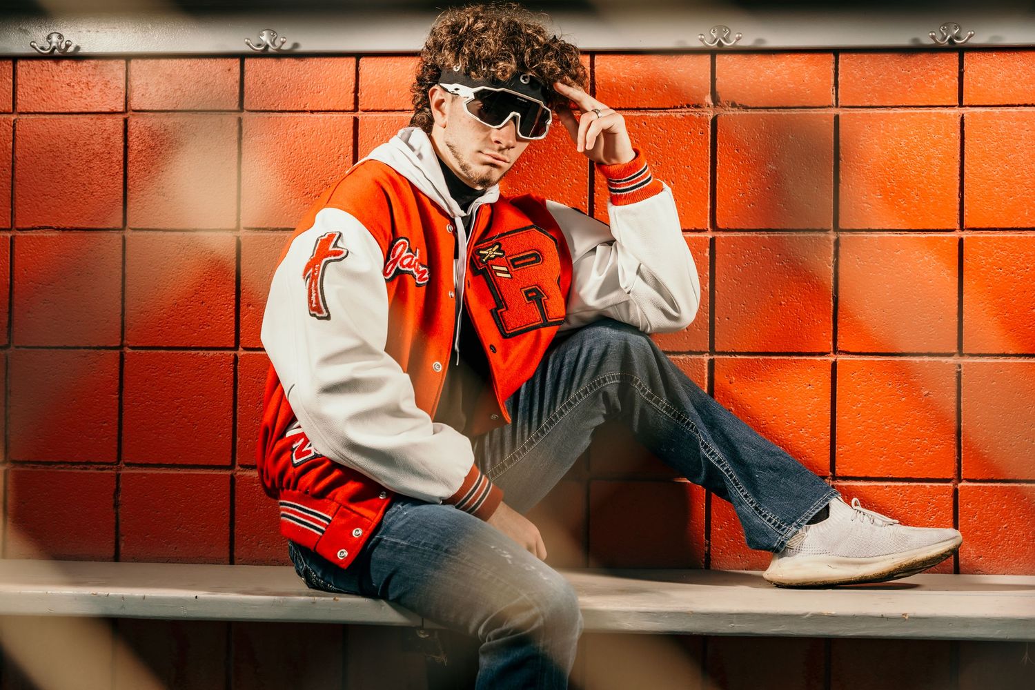 Athletic portrait series against dugout wall with dramatic lighting.