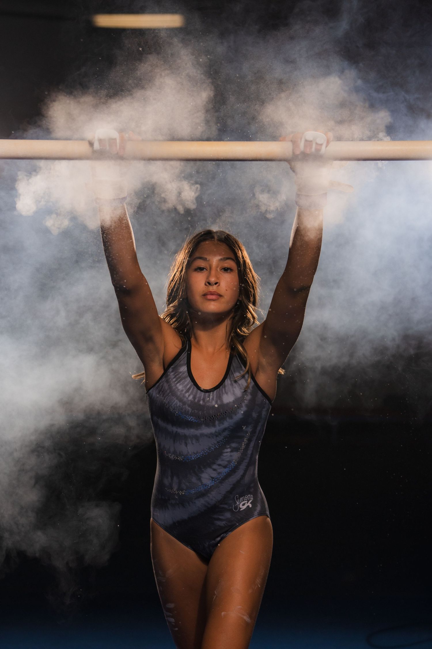 Gymnast gripping bar with chalk and fog captured by Dillon Lane Photography in Tri Cities.