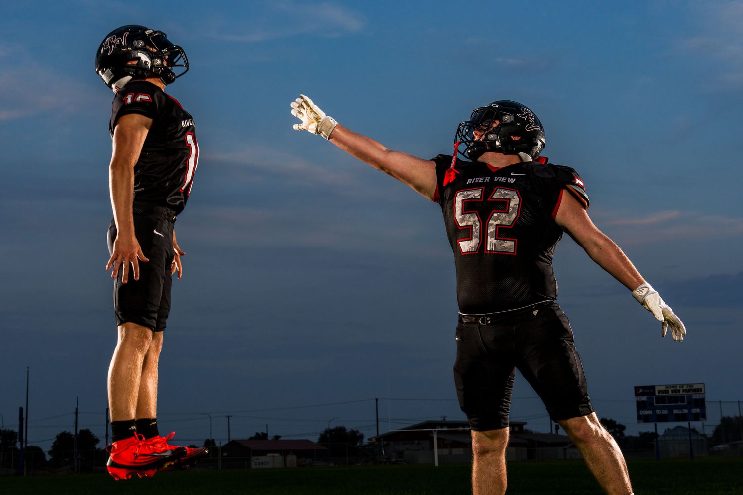 Football Media Day photo in Tri Cities WA with player leaping midair captured by Dillon Lane Photography showcasing dynamic team energy.