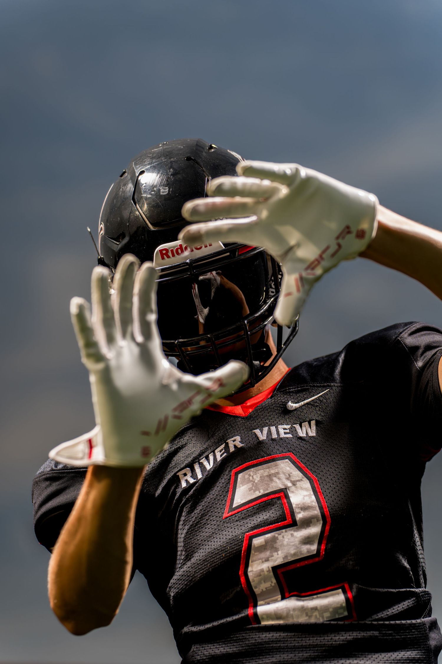 Football player portrait at Media Day with dramatic lighting and confident pose captured by Dillon Lane Photography.