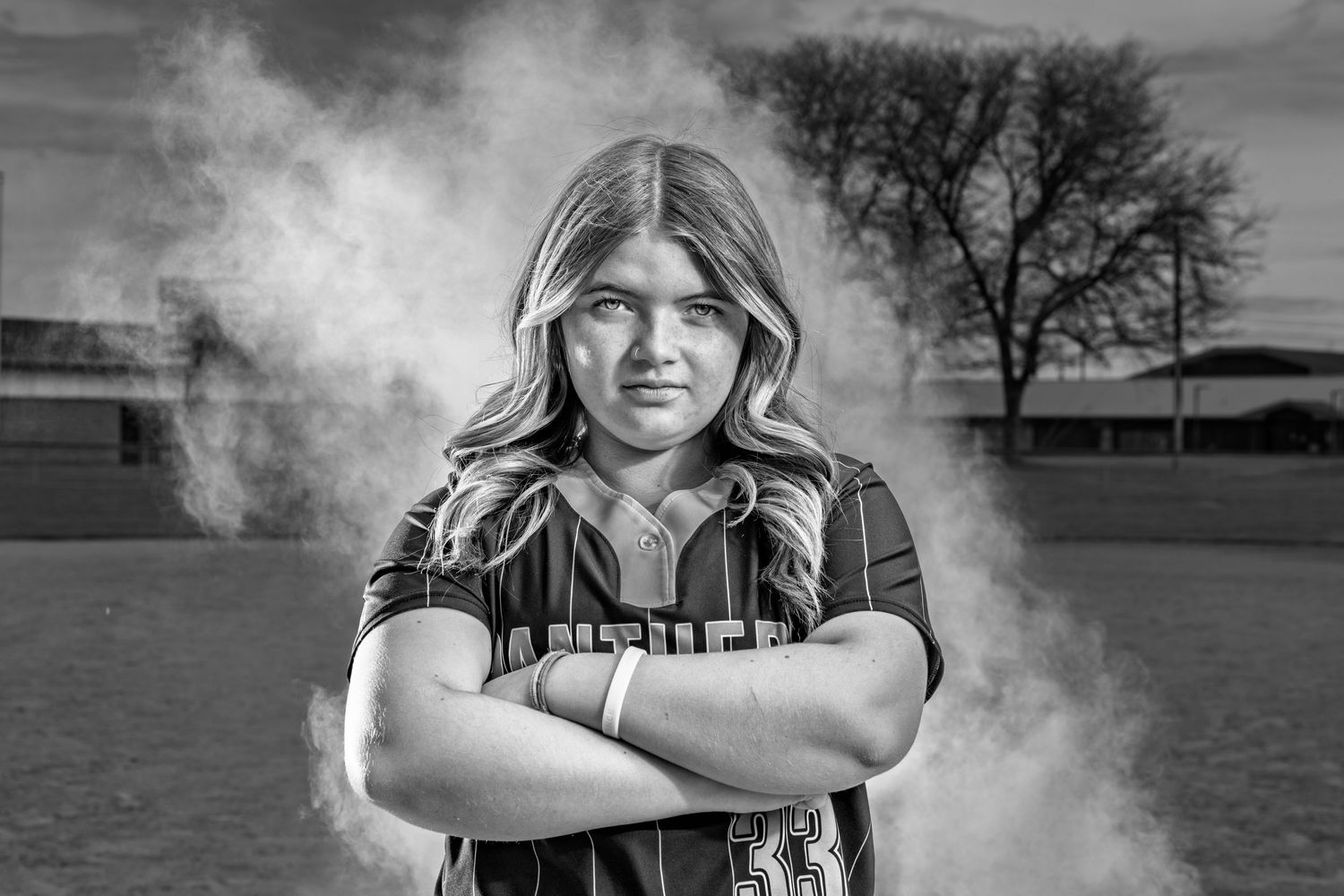 Black and white portraits of softball team members with dramatic smoke effects.