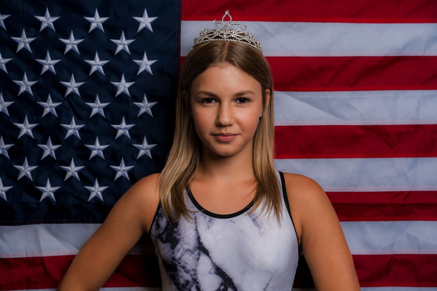 Portrait of athlete posing in front of American flag backdrop.