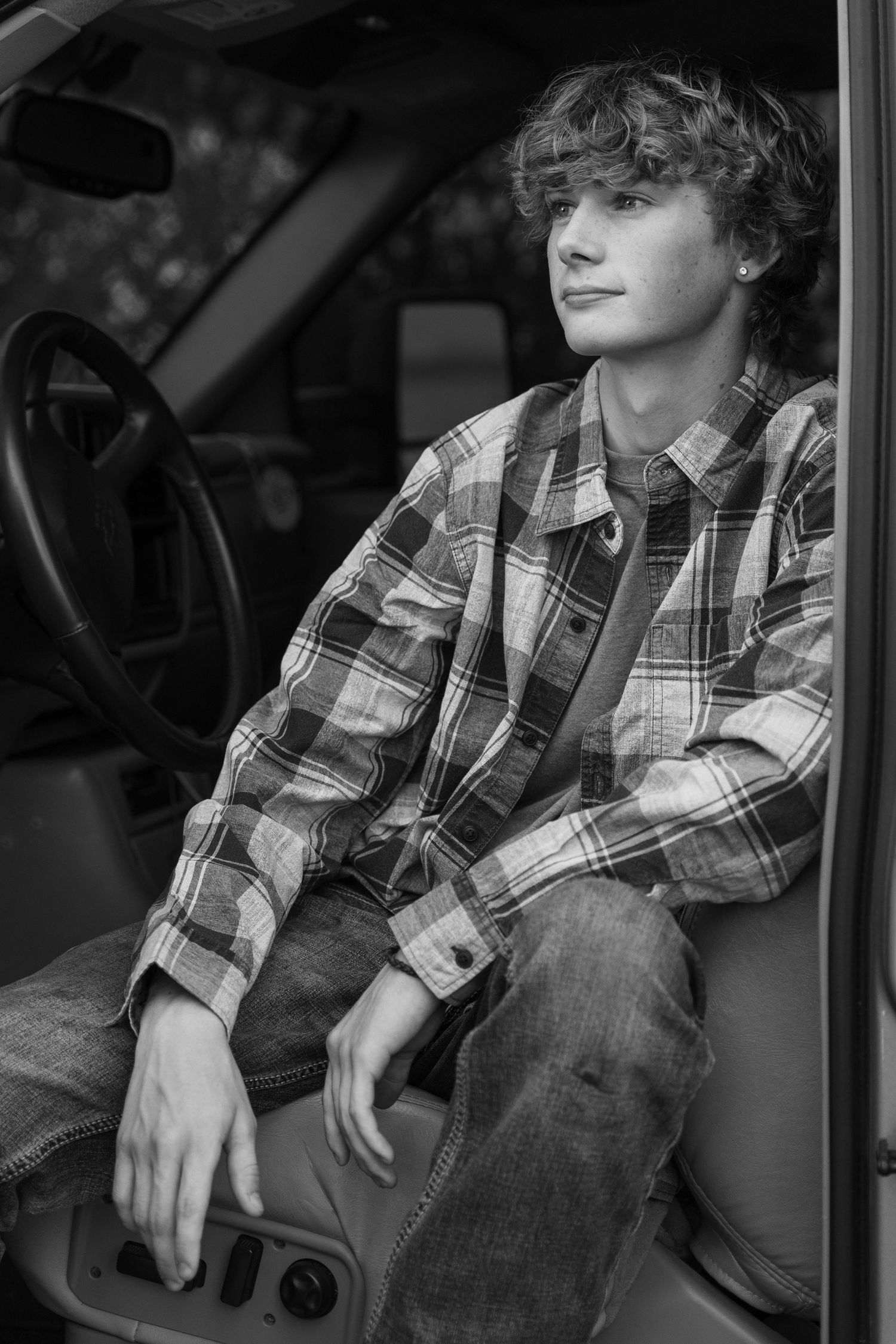 Senior guy sitting casually in black and white portrait.
