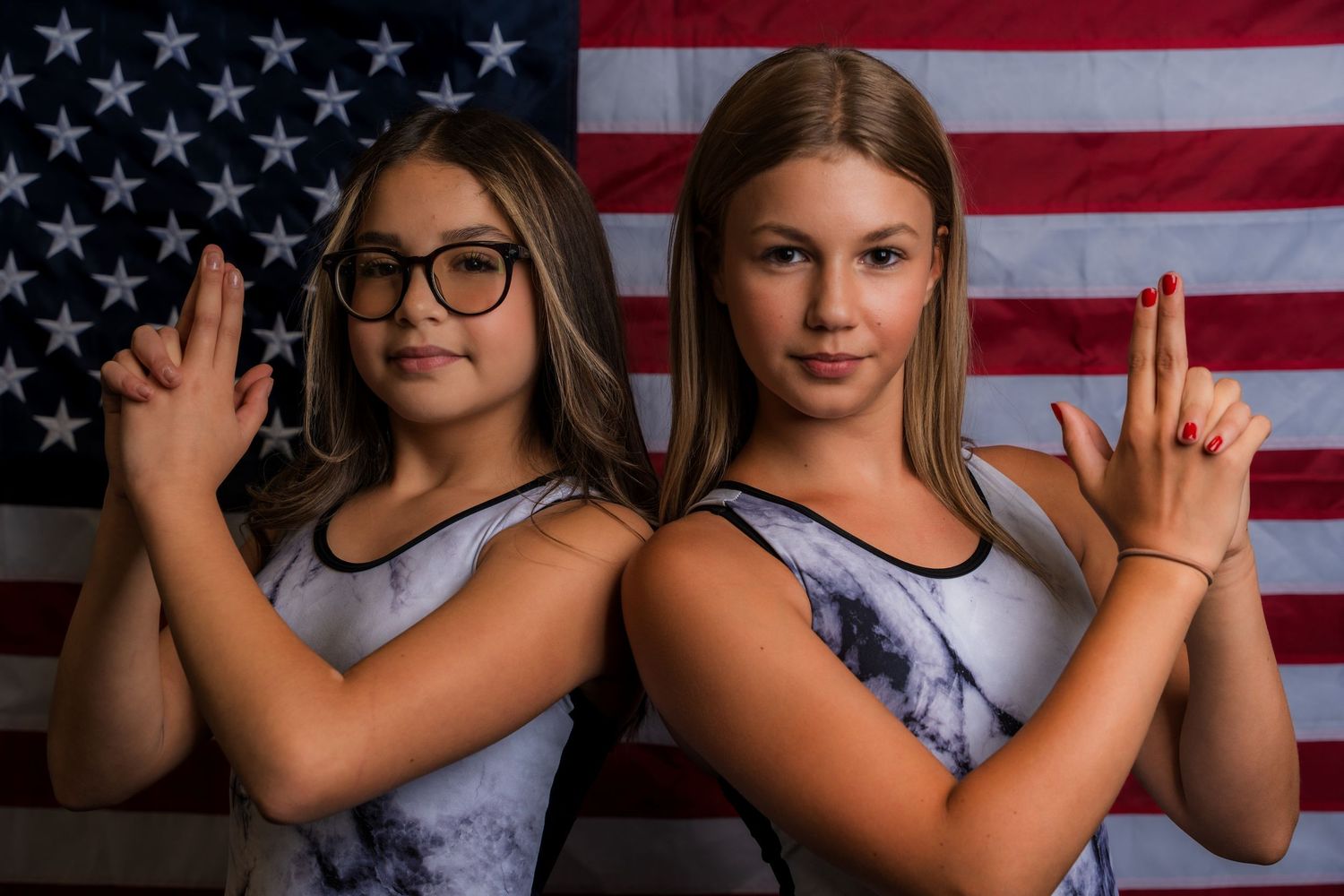 Athletes pose together with American flag backdrop showing team spirit.