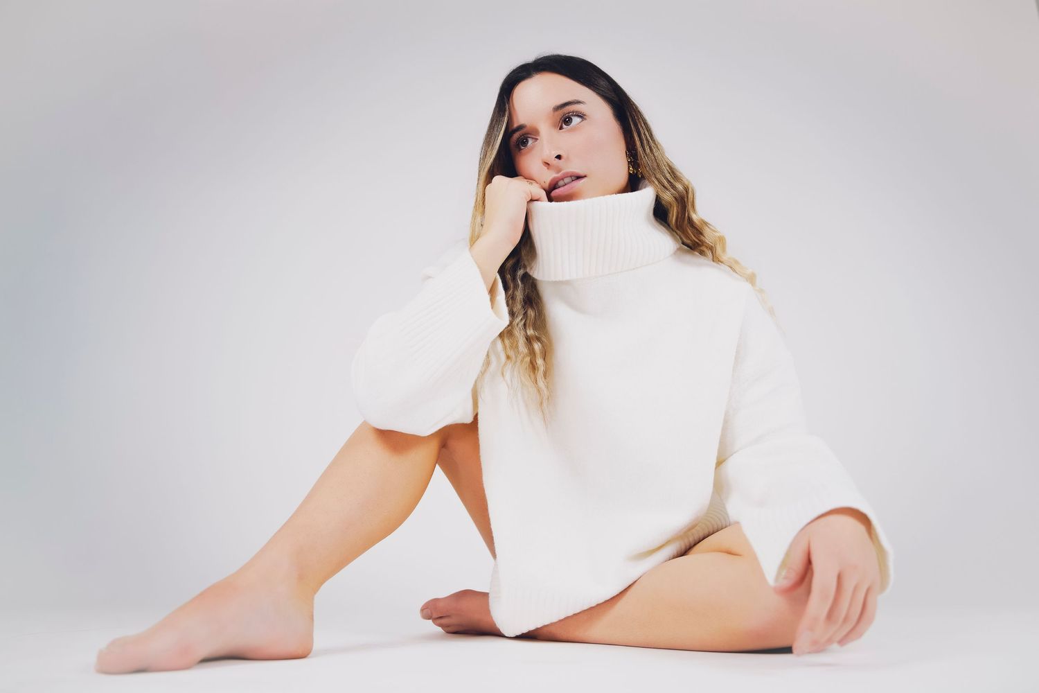 shooting photo studio sur fond blanc d'une femme habillée avec un pull blanc