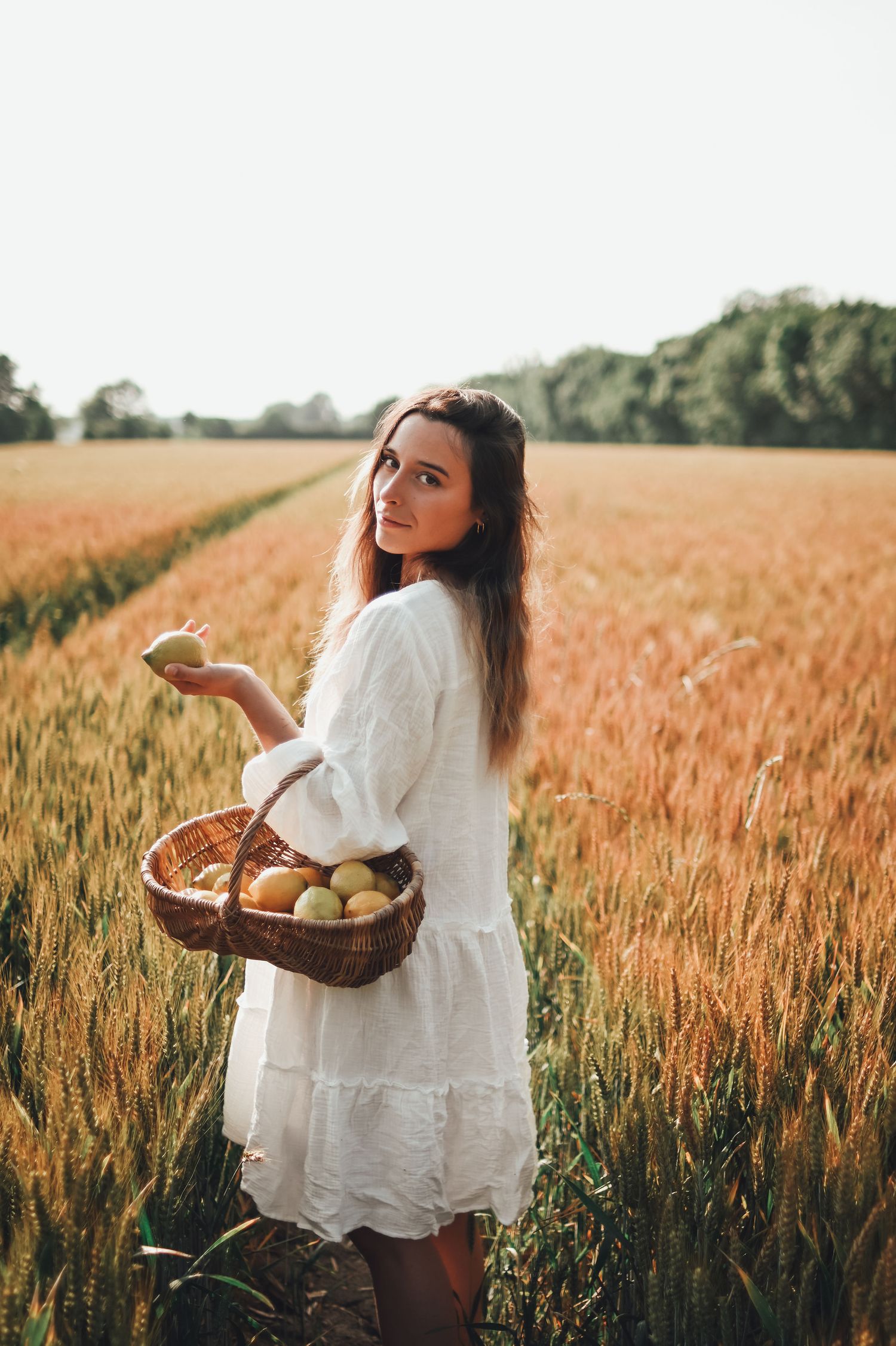 shooting photo d'une femme avec un panier de citron dans un champ de blé