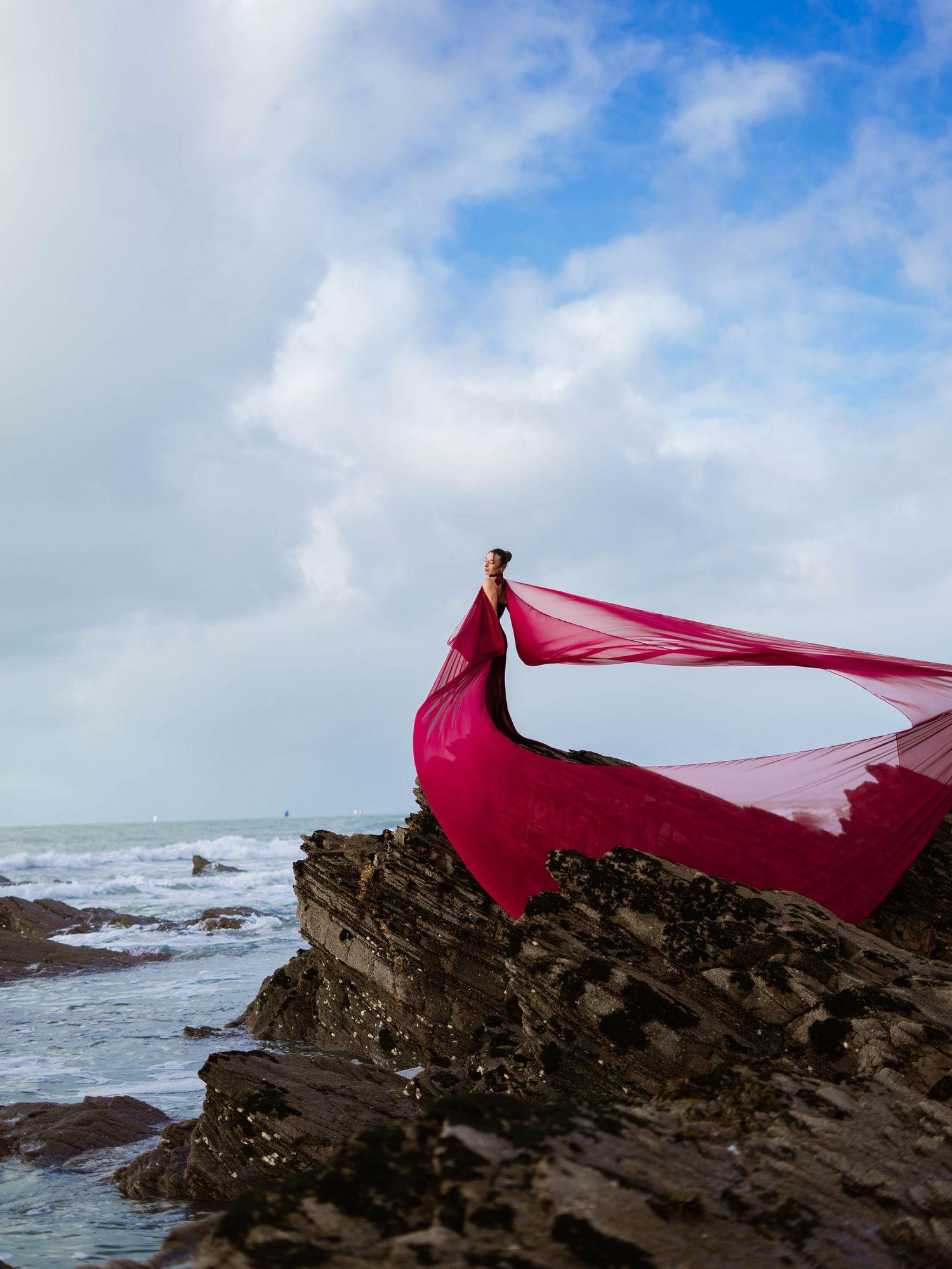 Modele photo en robe rouge au bord d'une falaise