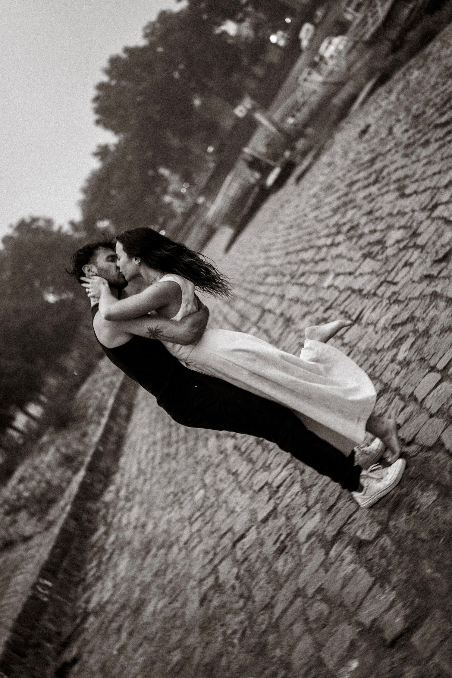 couple  sur le port d'Agers lors d'un shooting photo, on peut apercevoir un homme en vêtements noir et d'une femme en robe beige