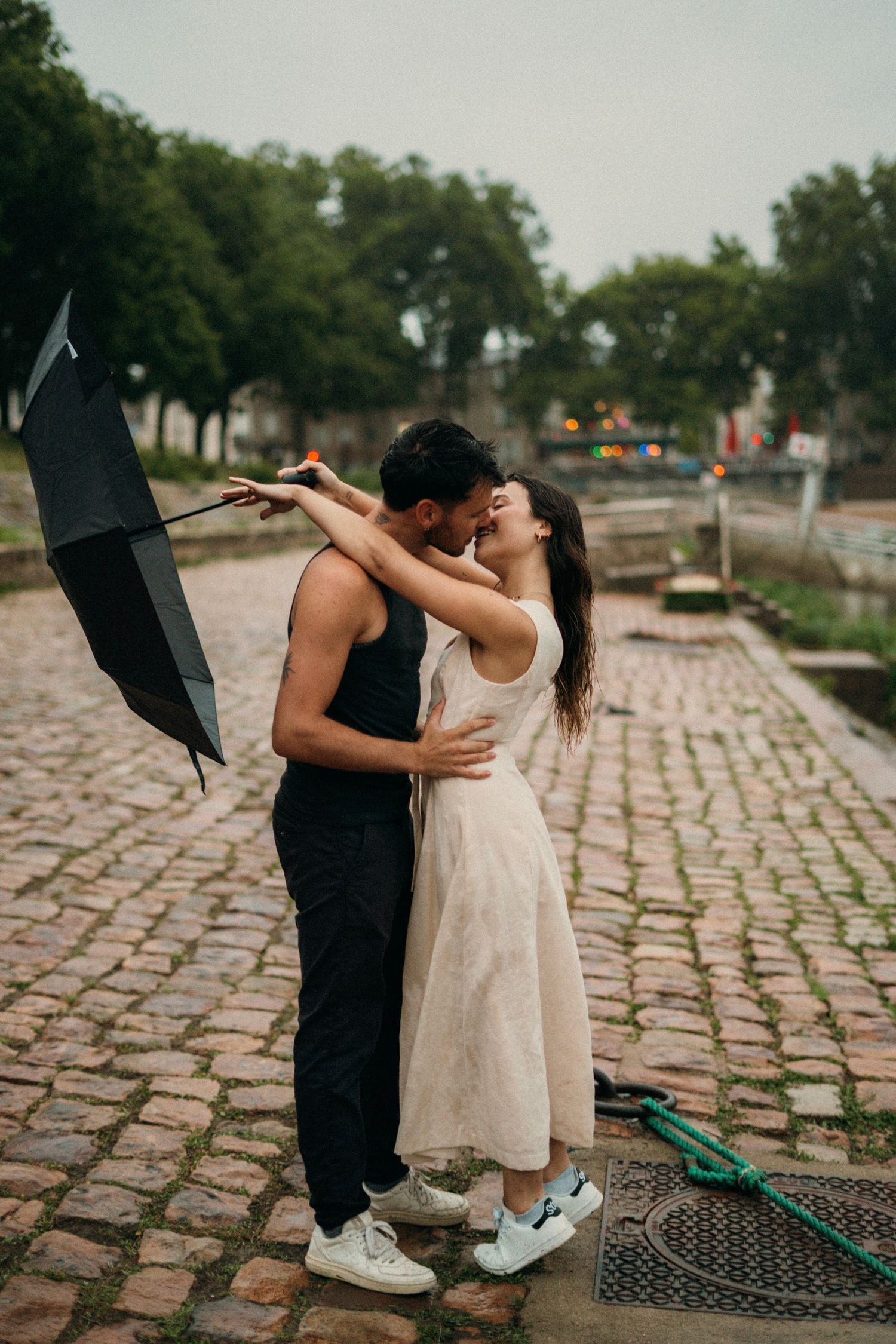 couple  sur le port d'Agers lors d'un shooting photo, on peut apercevoir un homme en vêtements noir et d'une femme en robe beige