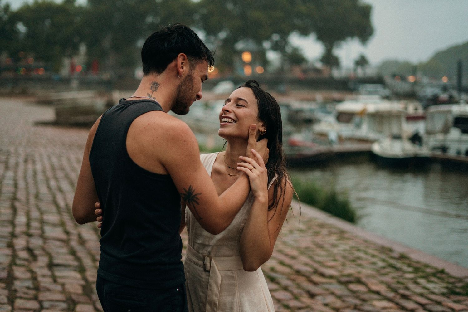 couple  sur le port d'Agers lors d'un shooting photo, on peut apercevoir un homme en vêtements noir et d'une femme en robe beige