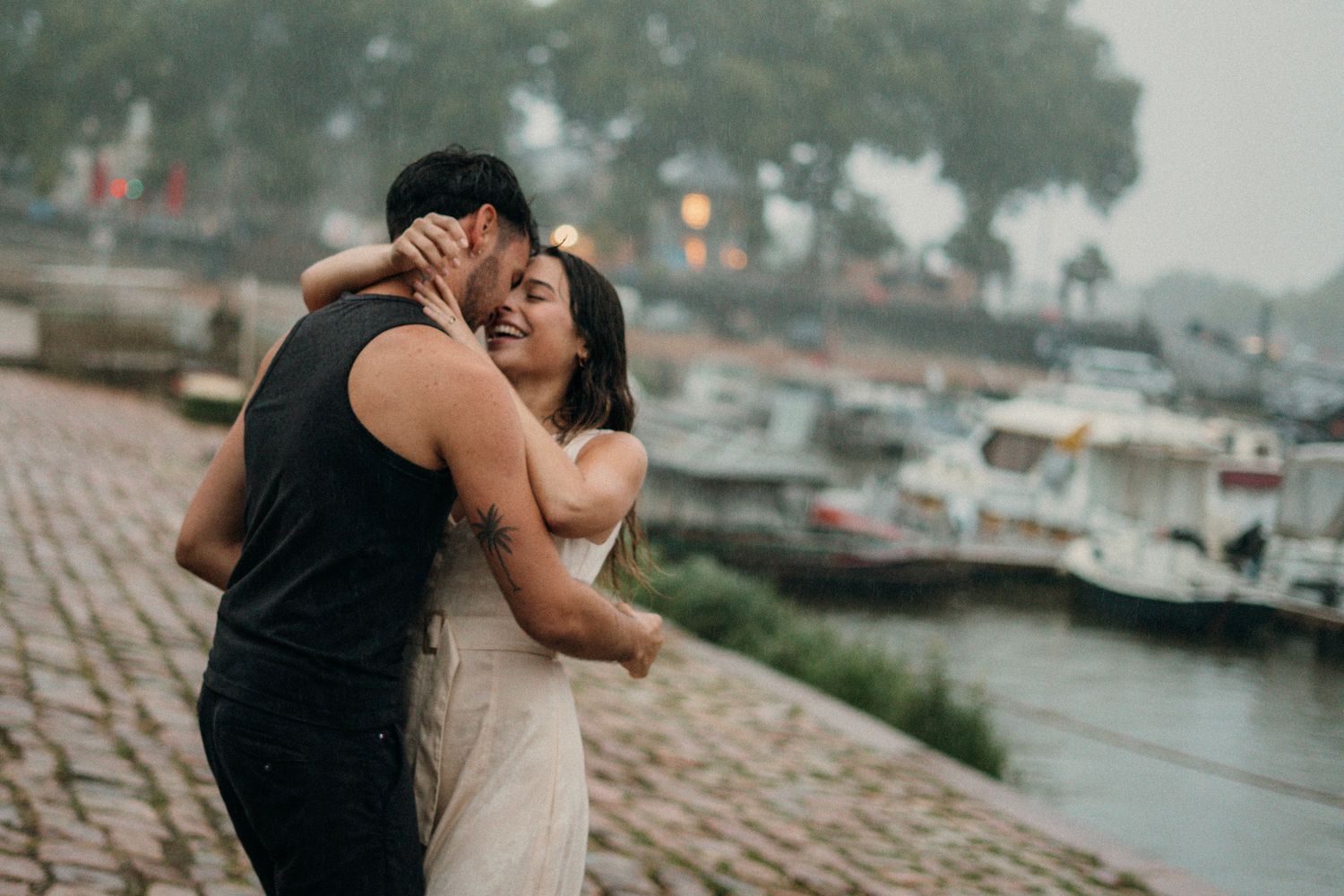 couple  sur le port d'Agers lors d'un shooting photo, on peut apercevoir un homme en vêtements noir et d'une femme en robe beige
