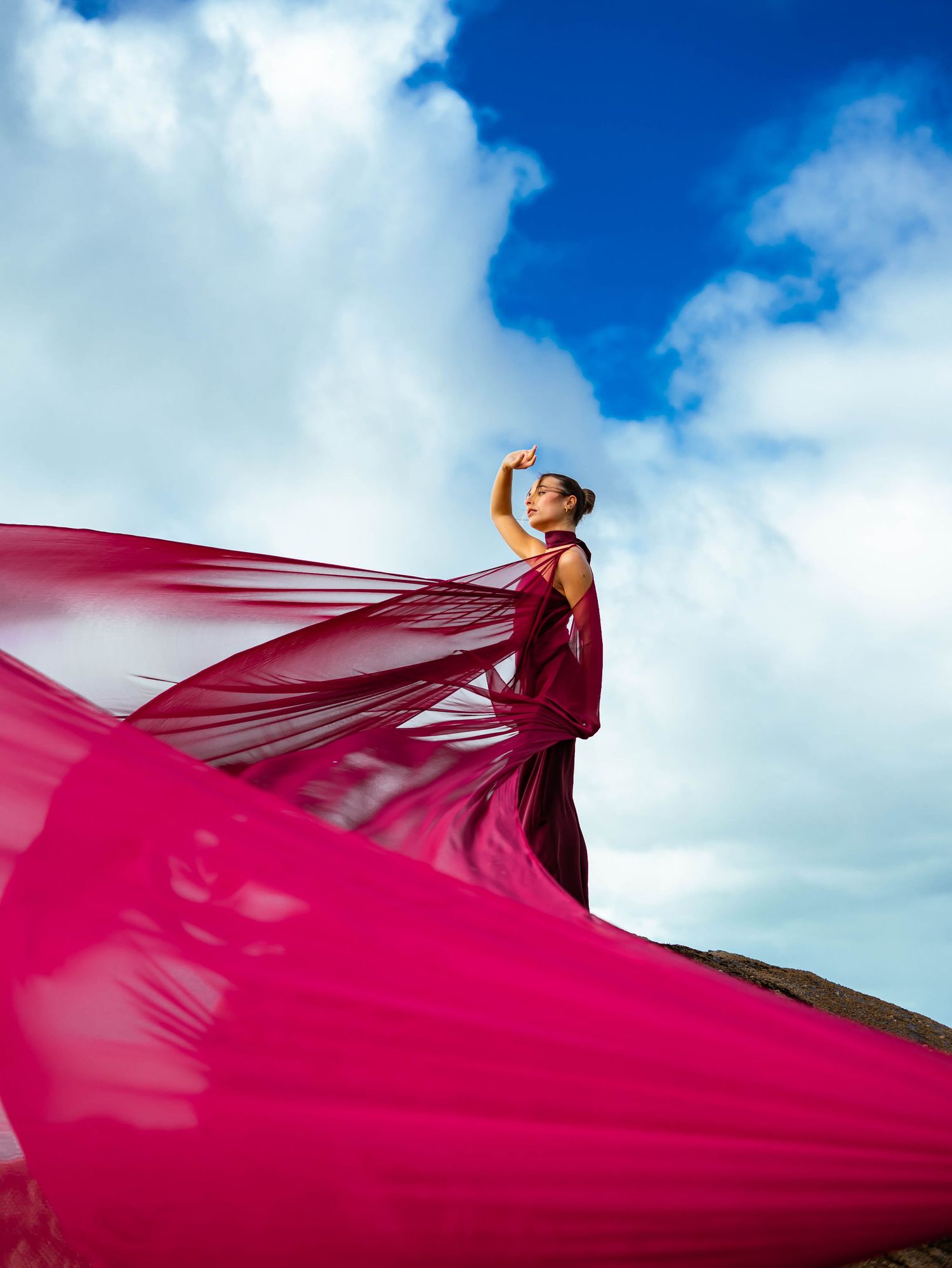Modele photo en robe rouge au bord d'une falaise
