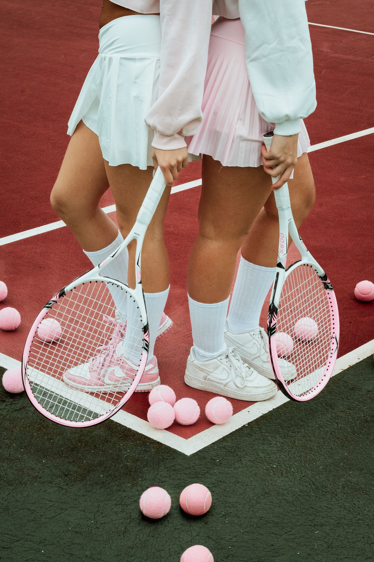 shooting photo sur un terrain de tennis avec deux femmes habillé en rose et blanc (pour octobre rose)