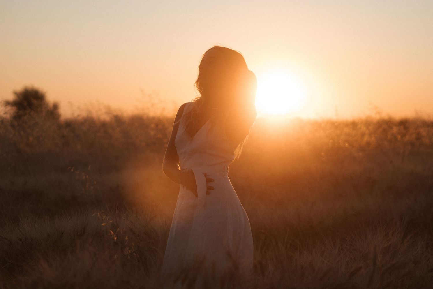 shooting photo dans un champ de blé avec une femme habillée d'une robe beige