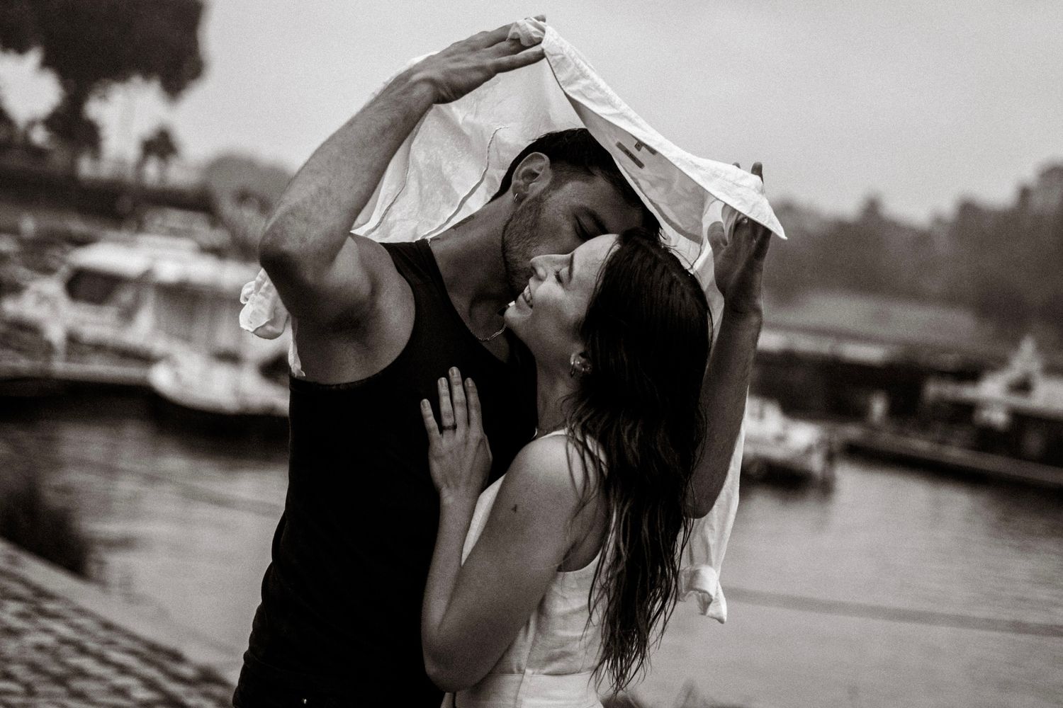 couple  sur le port d'Agers lors d'un shooting photo, on peut apercevoir un homme en vêtements noir et d'une femme en robe beige
