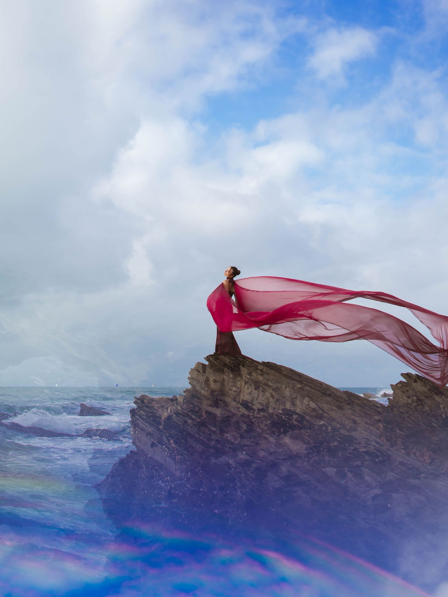 Modele photo en robe rouge au bord d'une falaise