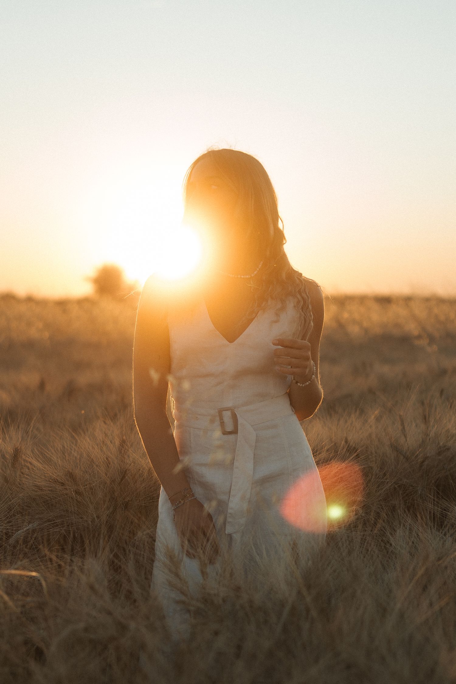 shooting photo dans un champ de blé avec une femme habillée d'une robe beige