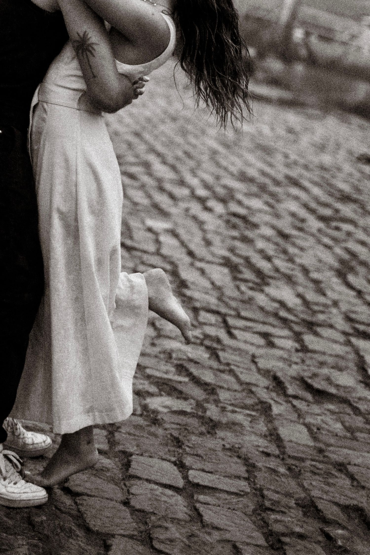 couple qui danse sur le port d'Agers lors d'un shooting photo, on peut apercevoir un homme en vêtements noir et d'une femme en robe beige