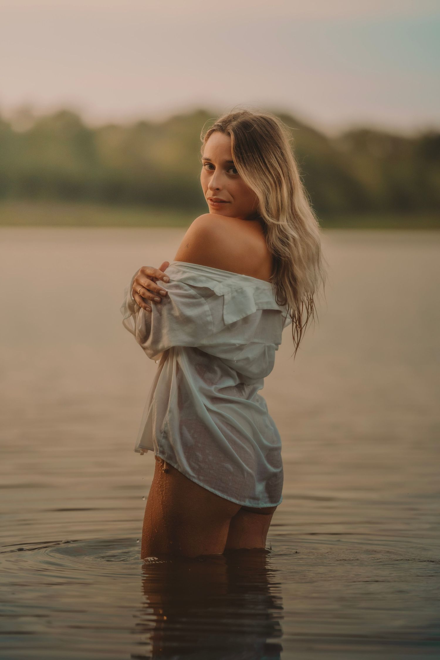 shooting photo d'une femme avec une chemise blanche au bord d'un lac