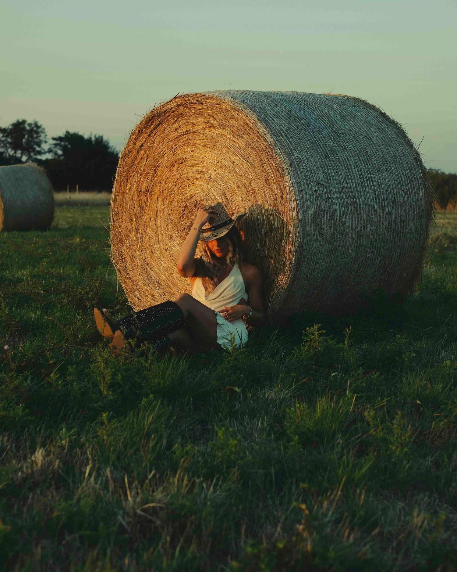 shooting photo style cowboy dans un champ de bottes de pailles
