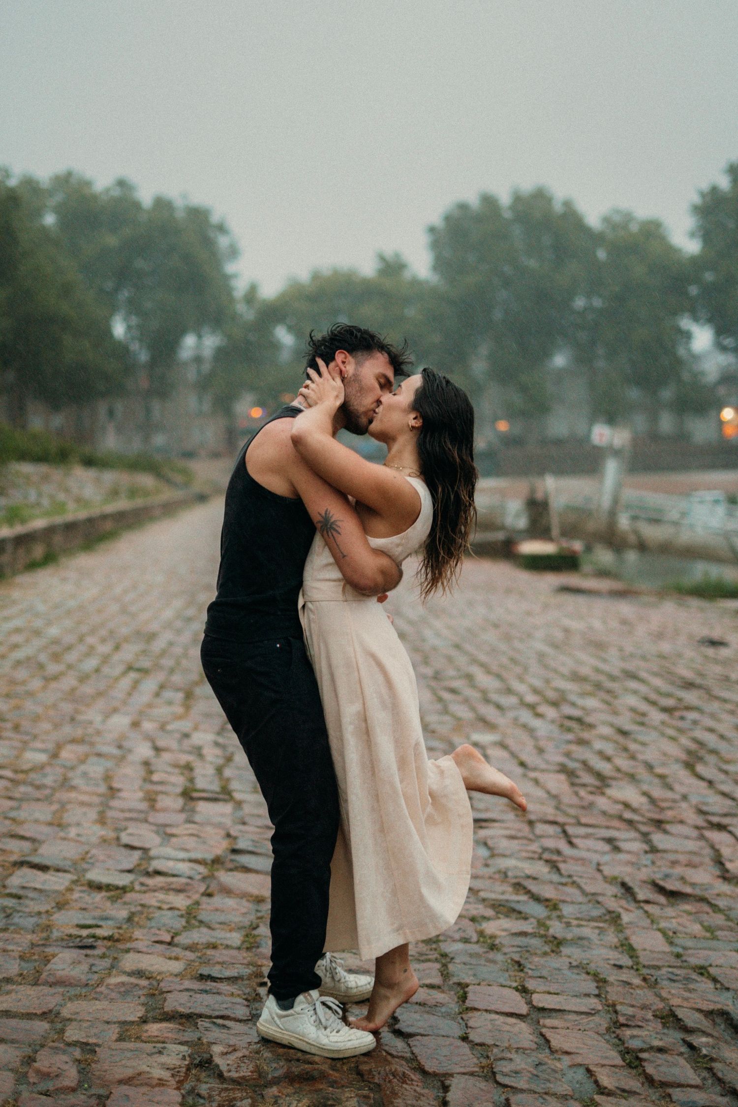 couple  sur le port d'Agers lors d'un shooting photo, on peut apercevoir un homme en vêtements noir et d'une femme en robe beige