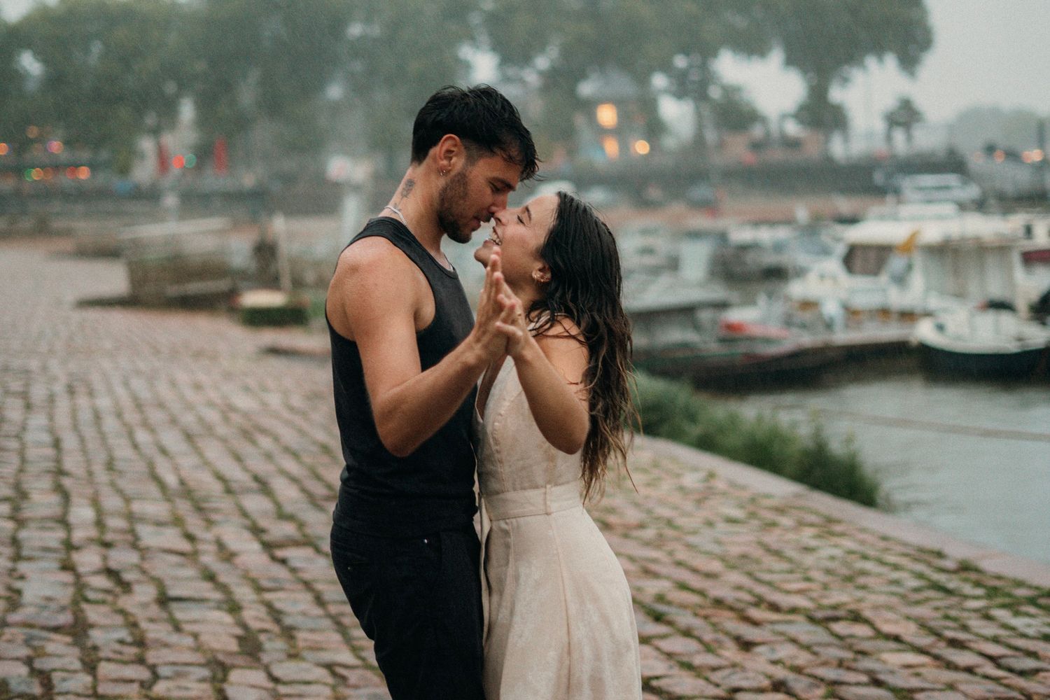 couple  sur le port d'Agers lors d'un shooting photo, on peut apercevoir un homme en vêtements noir et d'une femme en robe beige
