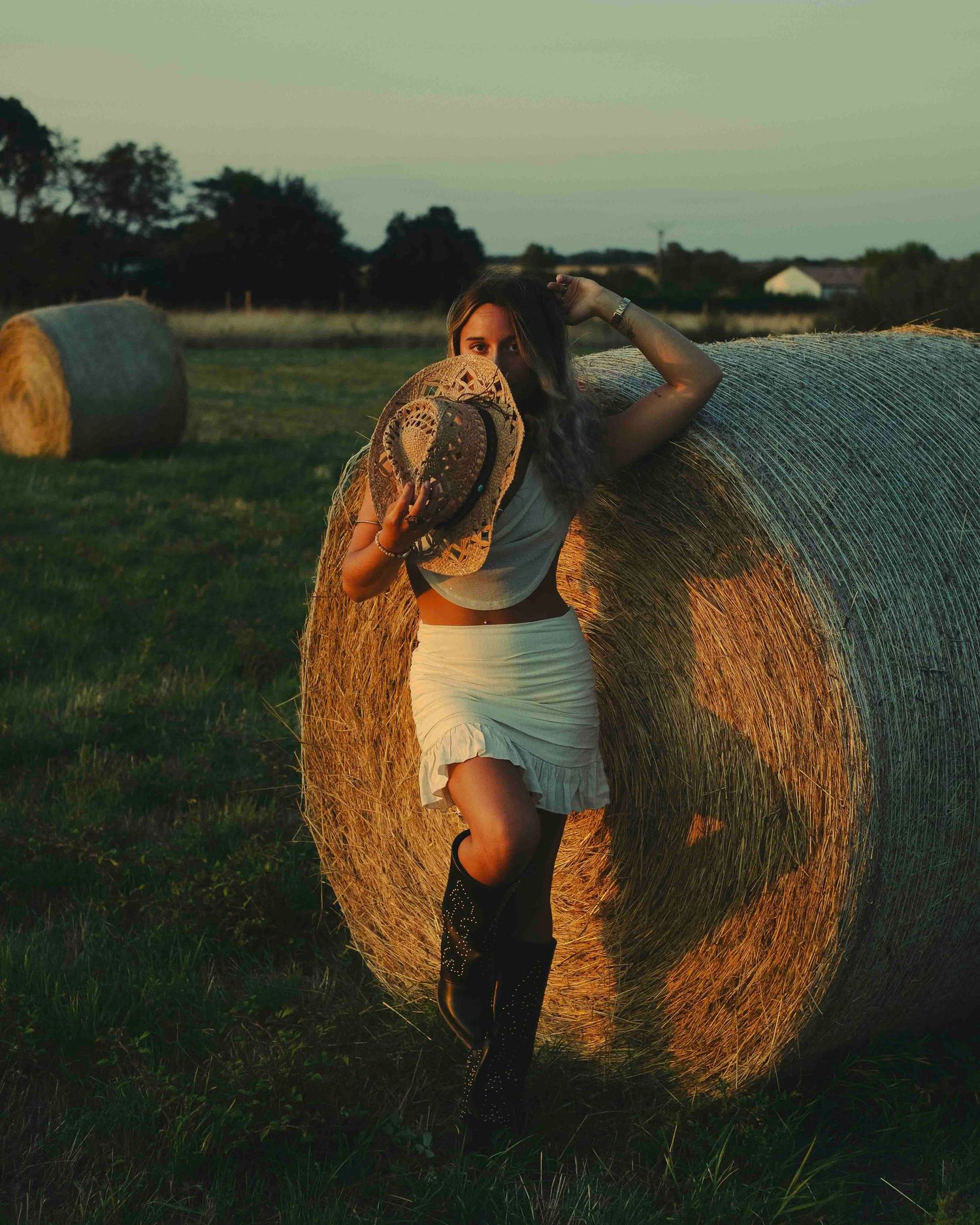 shooting photo style cowboy dans un champ de bottes de pailles