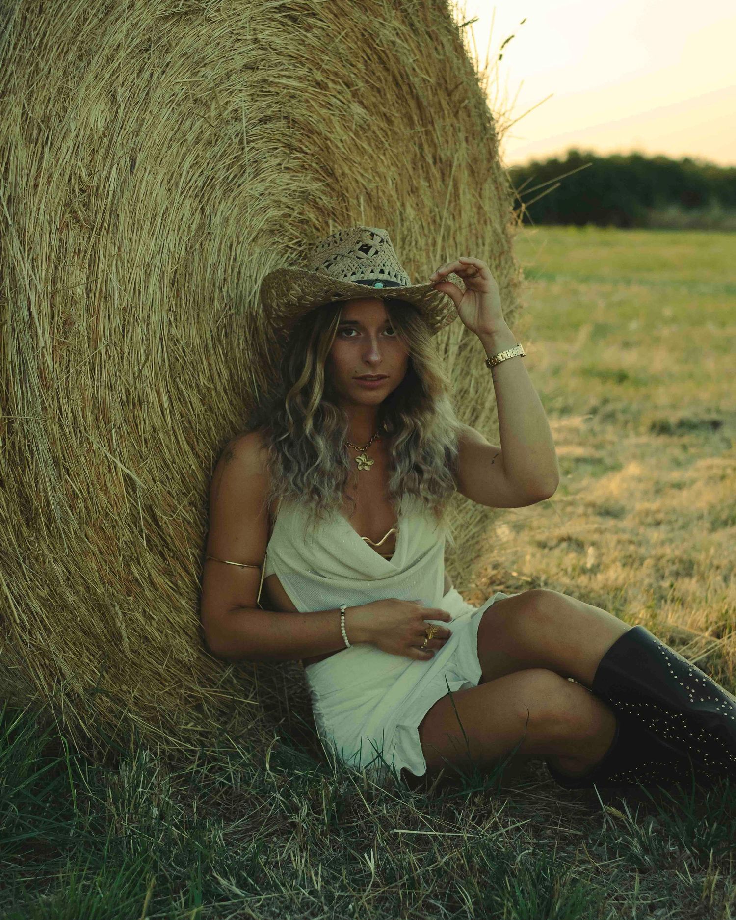 shooting photo style cowboy dans un champ de bottes de pailles