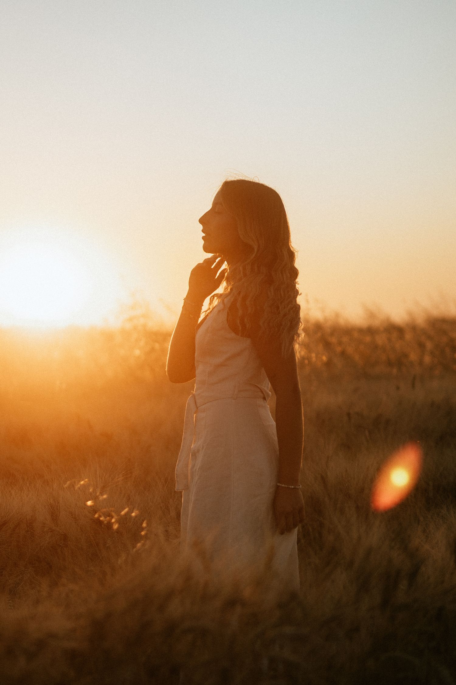 shooting photo dans un champ de blé avec une femme habillée d'une robe beige