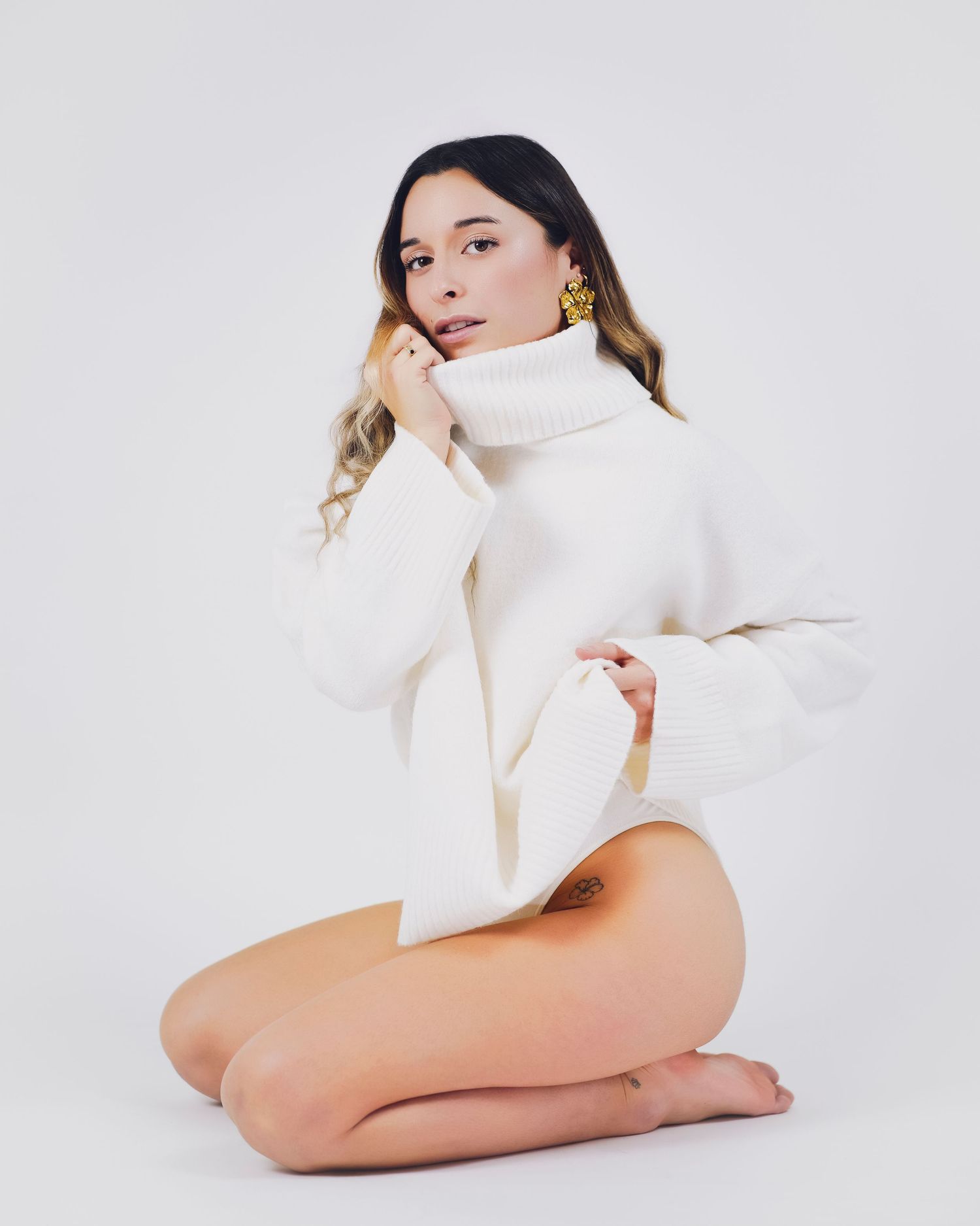 shooting photo studio sur fond blanc d'une femme habillée avec un pull blanc