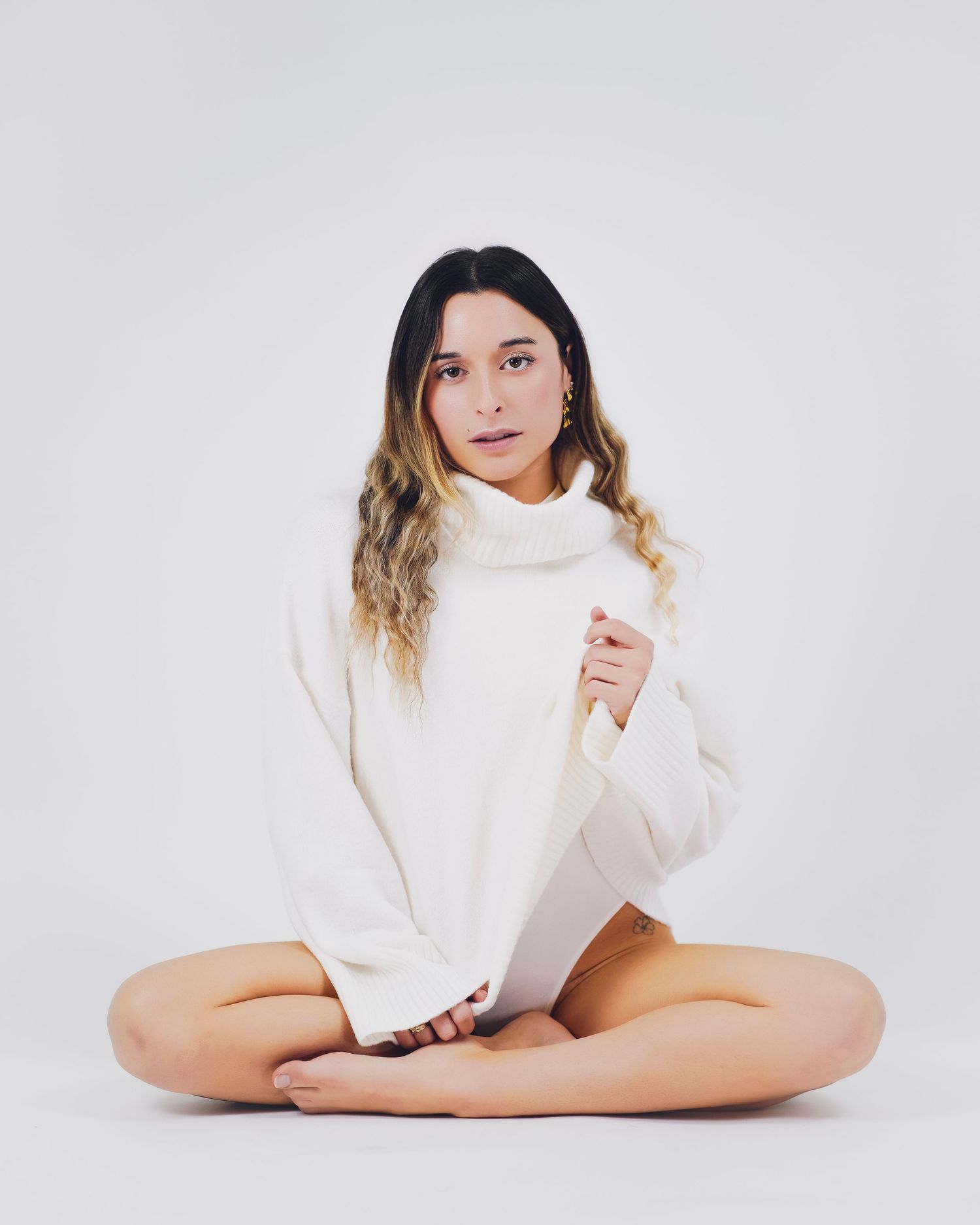 shooting photo studio sur fond blanc d'une femme habillée avec un pull blanc