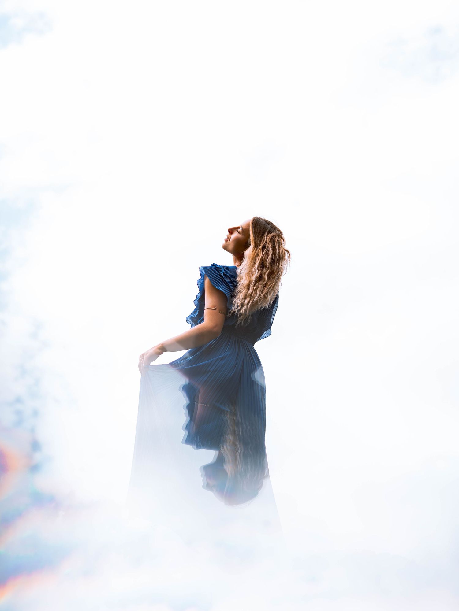 shooting photo illusion d'optique type ciel avec une femme habillée en bleu
