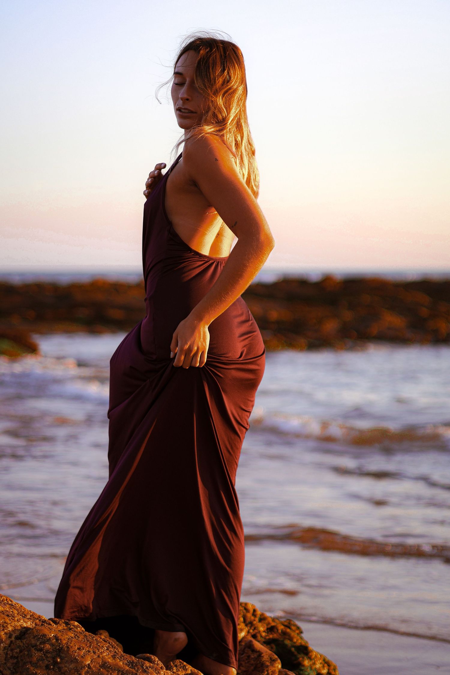 shooting photo d'une femme en robe bordeaux à la plage