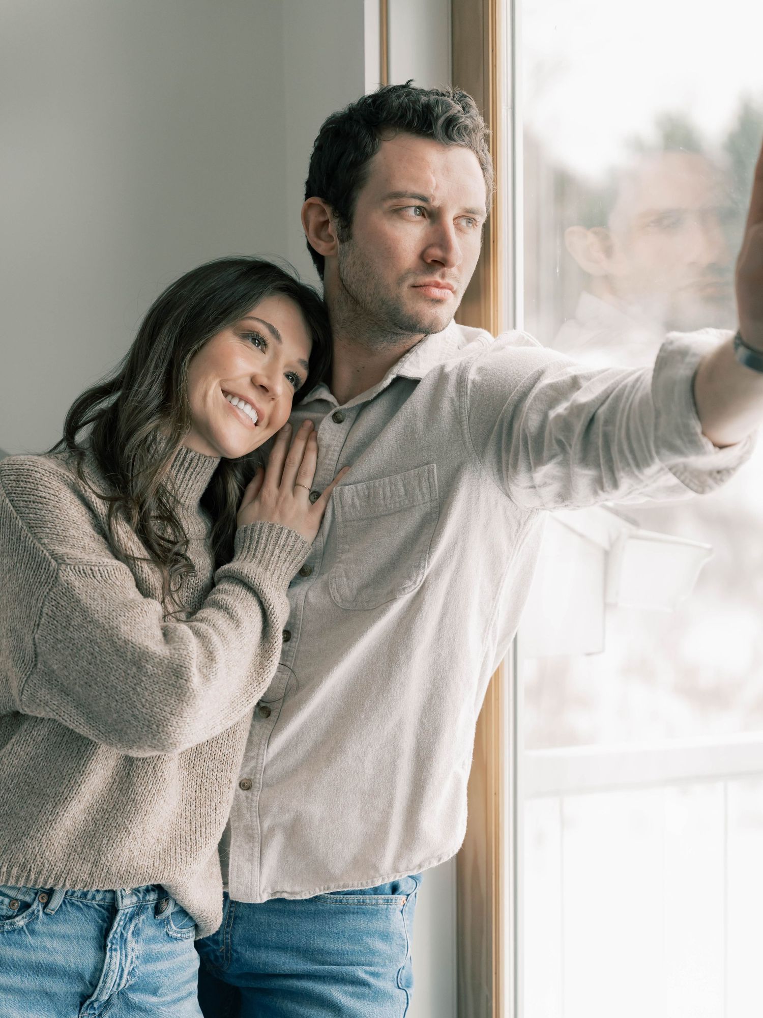 A couple in cozy sweaters shares intimate moments by a bright window in a series of romantic lifestyle photos.