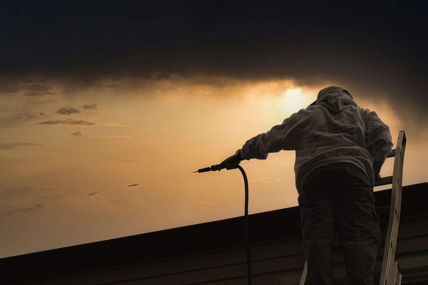 Silhouettes of military snipers with rifles against a dramatic sunset sky during a combat training exercise.