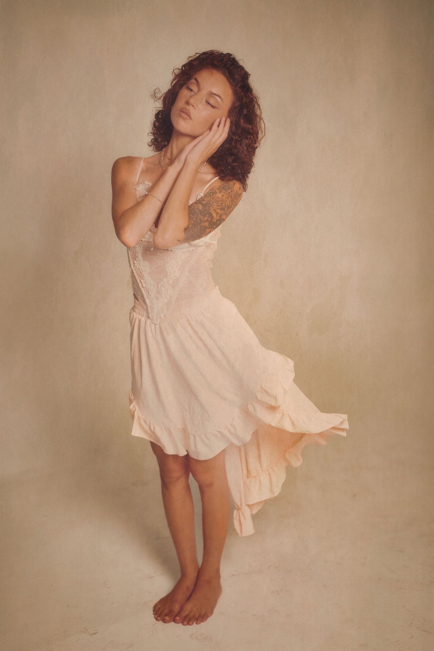 A figure in a flowing white dress dances gracefully against a sepia-toned background in a series of artistic poses.