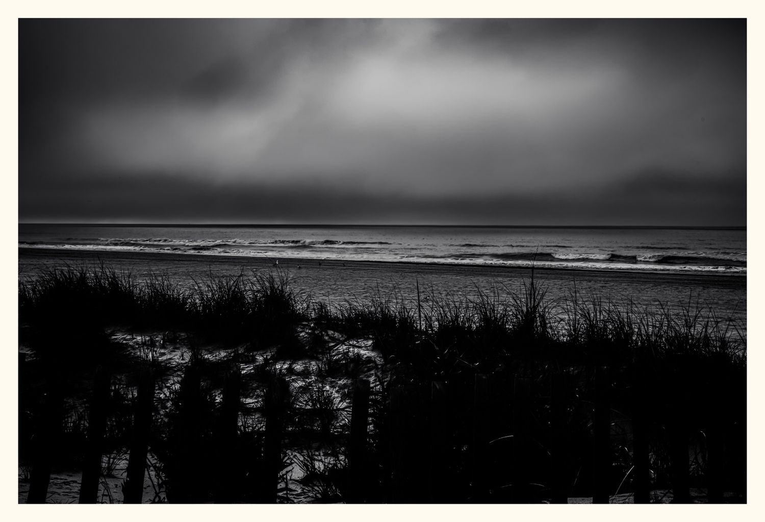 A moody black and white series of coastal beach landscapes with rolling waves and misty atmosphere.